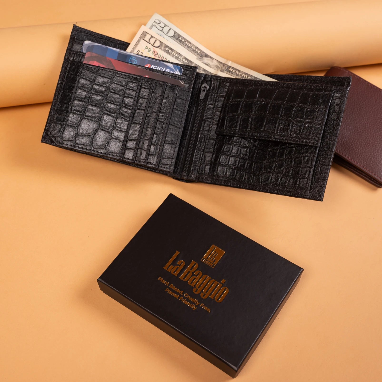 Black crocodile-patterned vegan leather wallet for men with money and cards on a beige surface, next to a black box with 'La Baggio' branding.