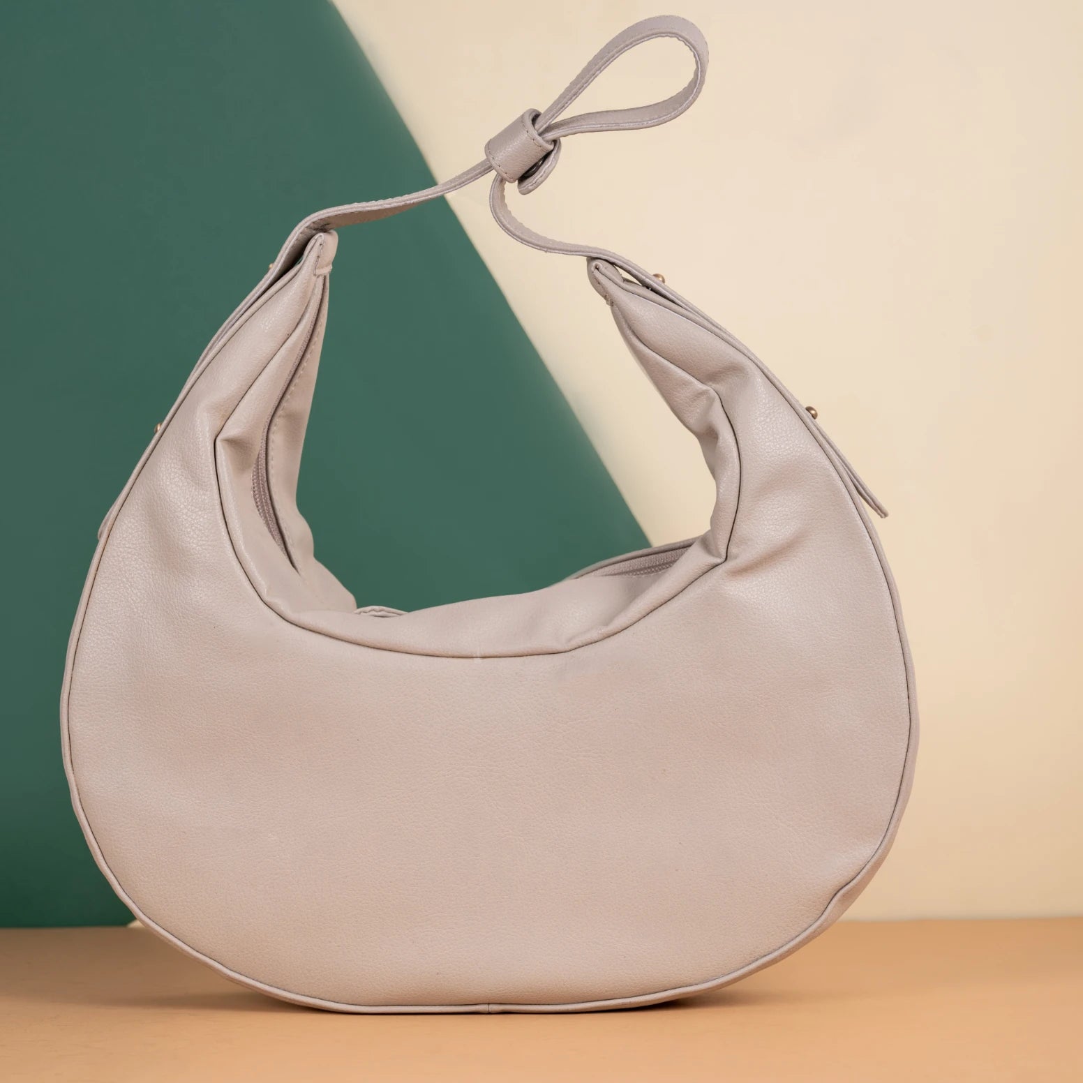Beige vegan leather handbag for women on a two-tone background