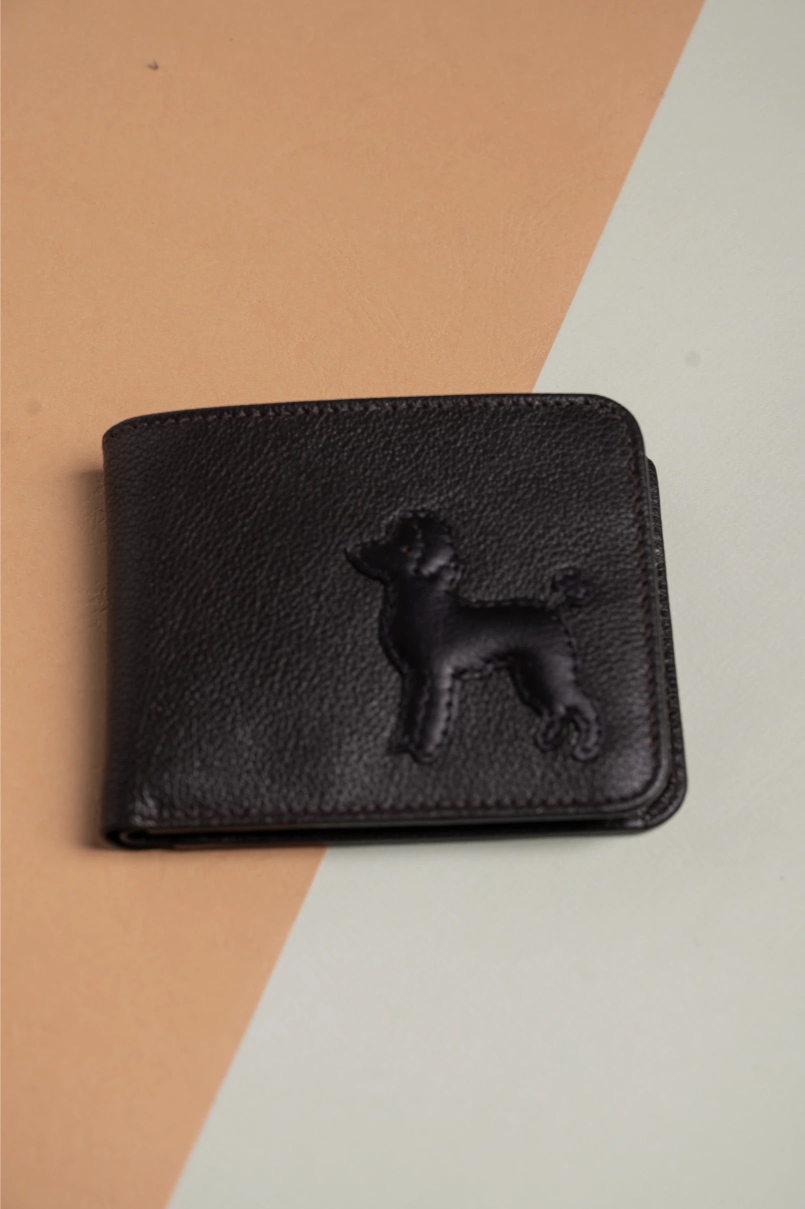 Black vegan leather wallet for women with a dog embossing on a multicolored background