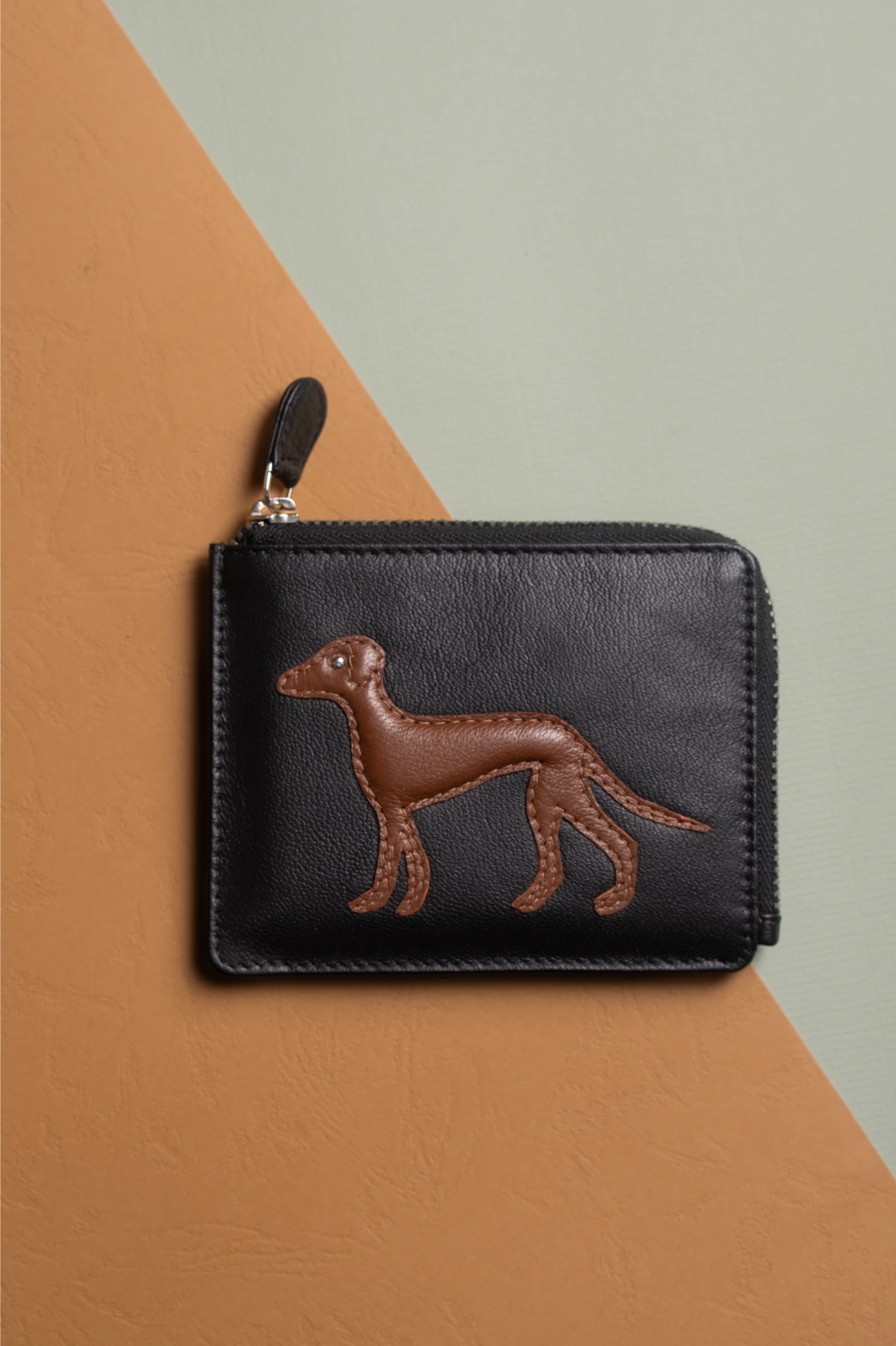 Black vegan leather wallet for women with brown dog embossing on a two-tone background