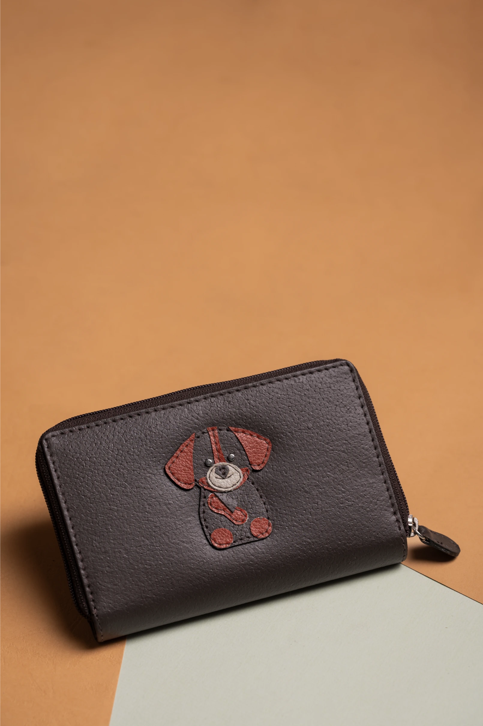Black vegan leather wallet for women with a dog design on a brown background