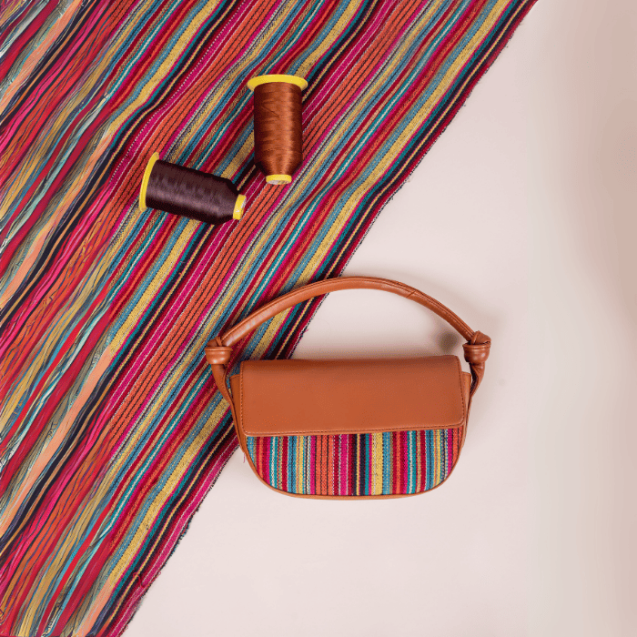 Brown vegan leather handbag for women with colorful striped fabric on a white background
