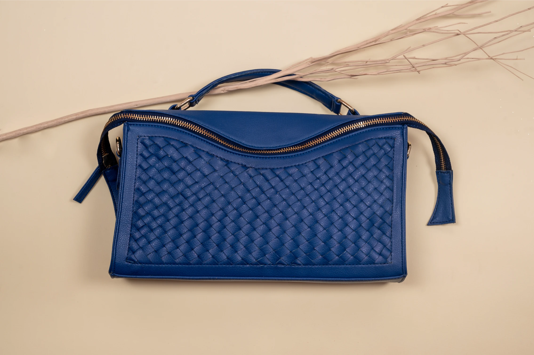 Blue woven vegan leather handbag for women on a beige background
