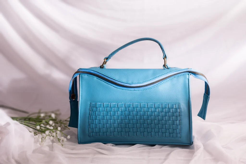Blue vegan leather handbag for women with woven pattern on a white background