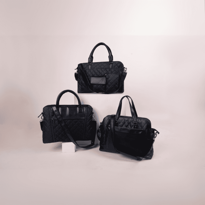 Three black vegan leather handbags of different sizes on a light gray background