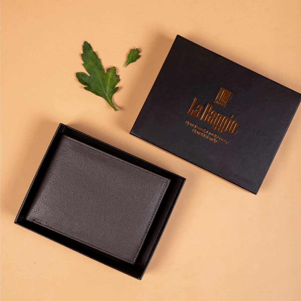 Black vegan leather wallet for men in an open box with 'La Bambino' branding on a beige background.