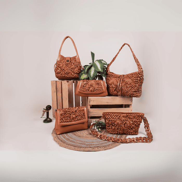 Collection of brown woven vegan leather handbags for women on a wooden crate with a neutral background