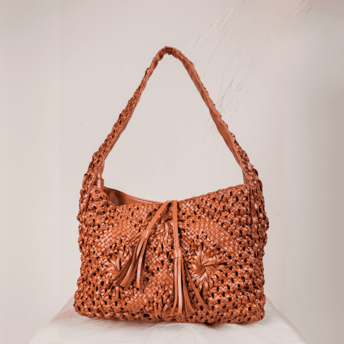 Brown woven vegan leather handbag for women with tassels on a white background