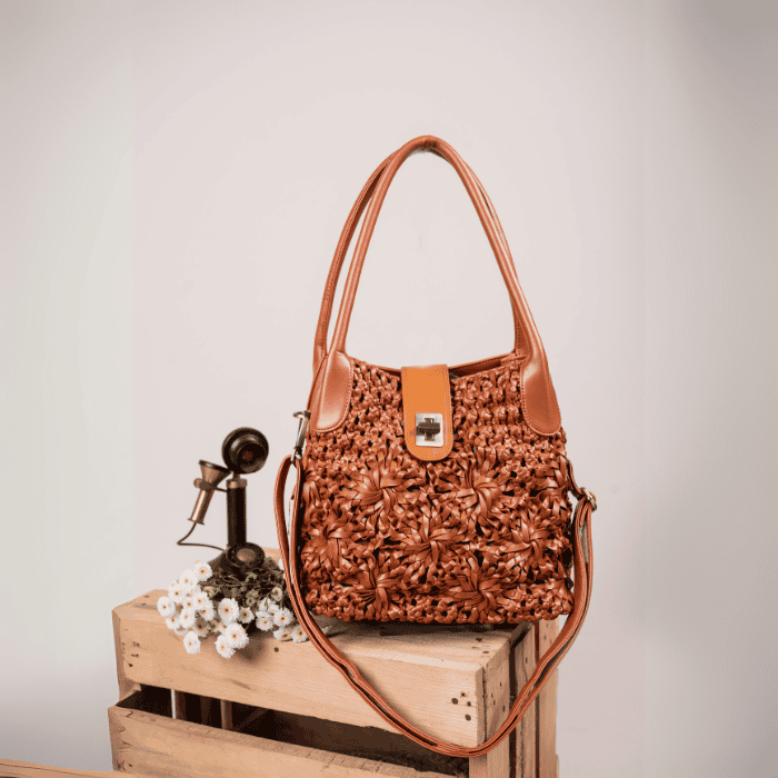 Brown textured vegan leather handbag for women on a wooden crate with a neutral background