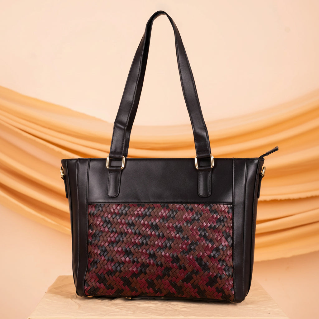 Black vegan leather handbag for women with patterned red and black section on a beige background