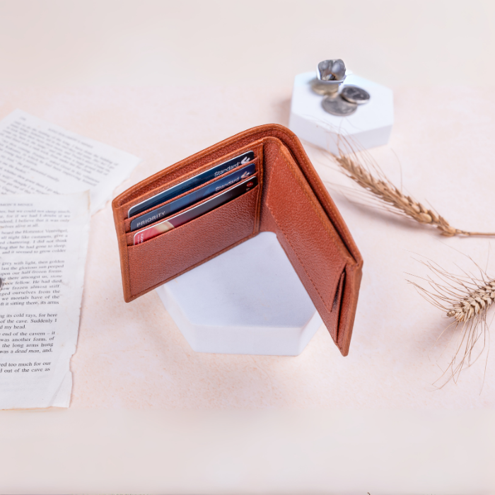 Brown vegan leather wallet for women with card slots on a light surface with a book and small plant.