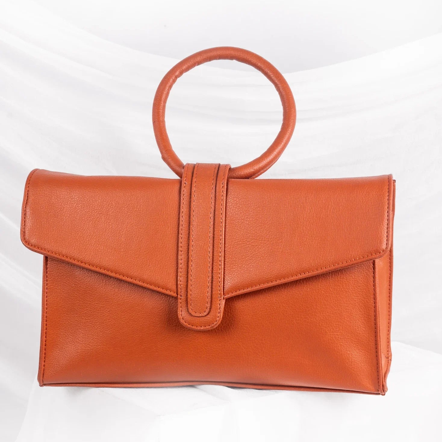 Brown vegan leather handbag for women with round handle on a white background