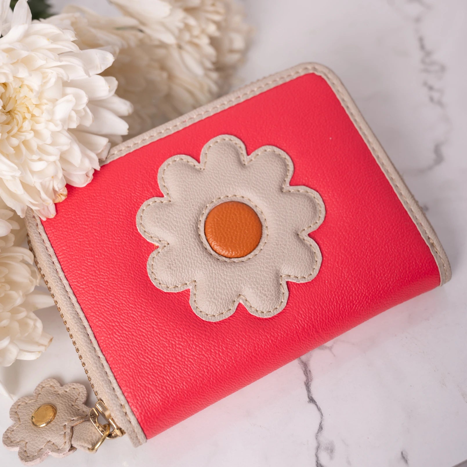 Red vegan leather wallet for women with a flower design on a marble surface
