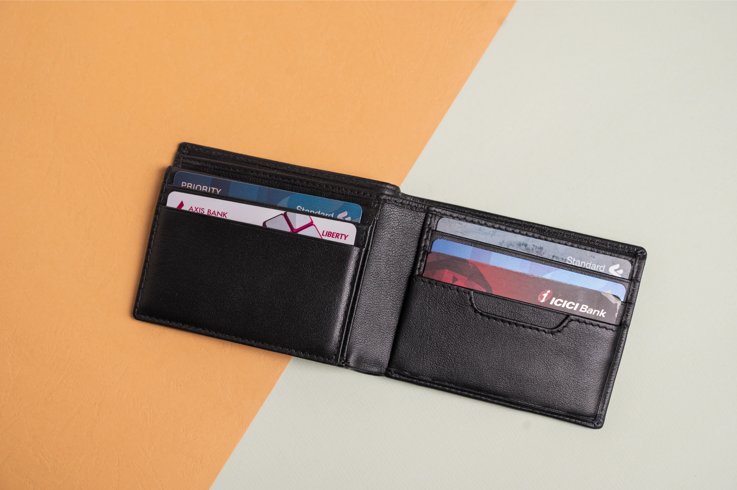 Black vegan leather wallet for women with cards on a two-tone background