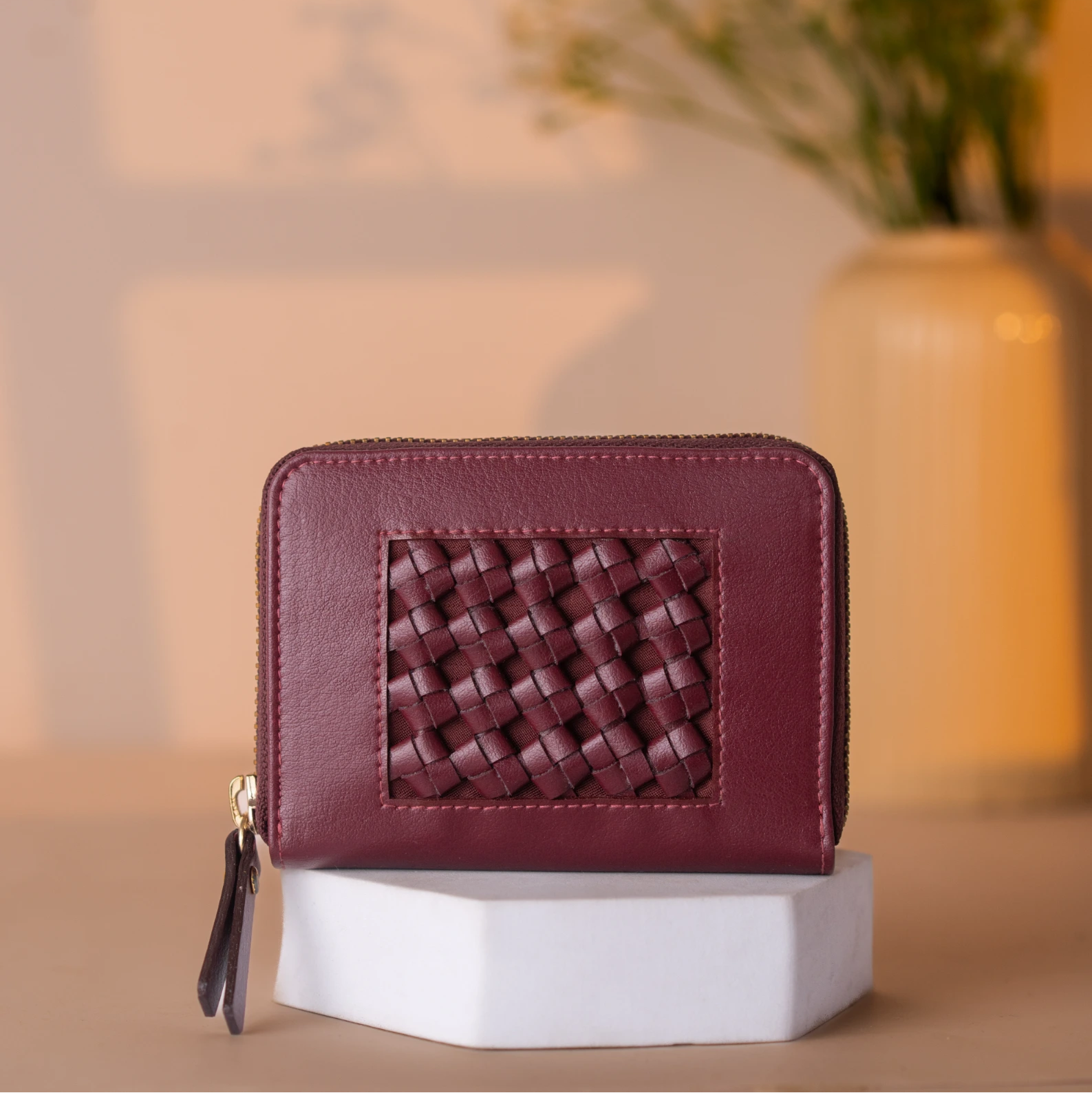 Maroon woven Vegan Leather Wallet for women on a white stand with a blurred background