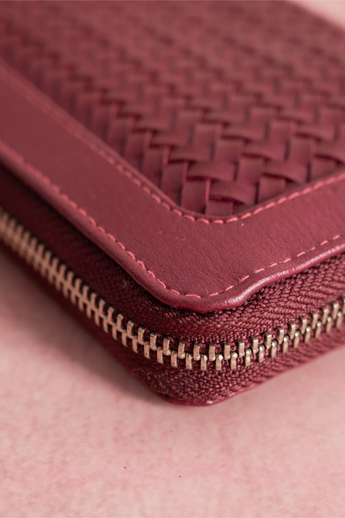 Close-up of a maroon woven Vegan Leather Wallet for women with a zipper.