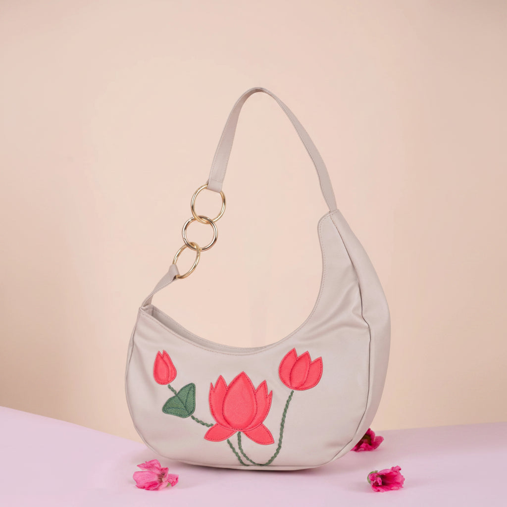 Light gray vegan leather handbag for women with pink floral embroidery on a beige background 