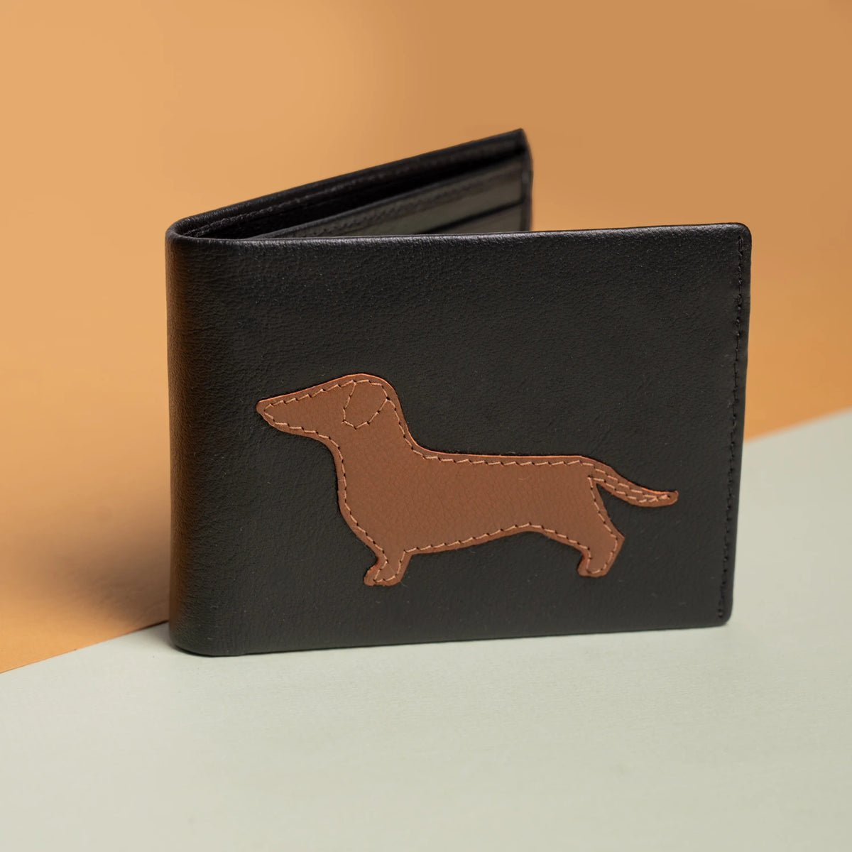 Black vegan leather wallet for women with a brown dachshund silhouette on a gradient background